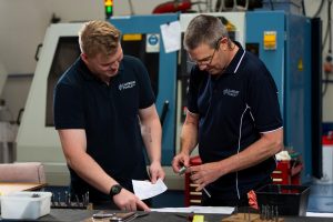 Two Carbide Tools Ltd engineers reviewing technical drawings and tool measurements inside a precision machining workshop in New Zealand.
